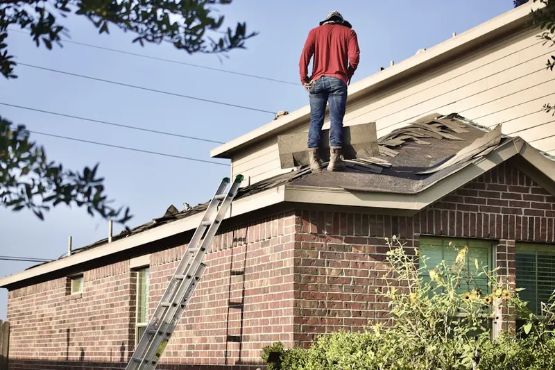 Professional roofer working on a residential roof in Somerville